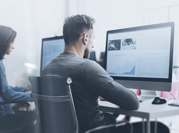 Office setting with a man and woman working intently on their computers in a modern environment.