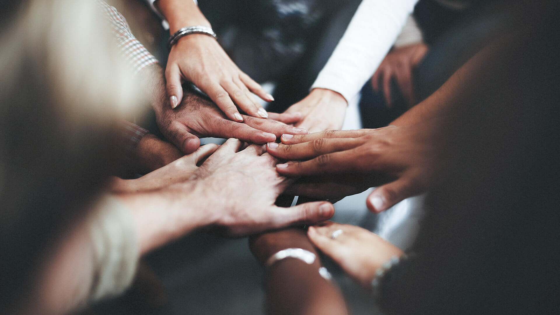 Hands of diverse people stacked together 